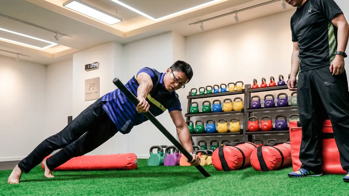 Bo Li demonstrating core strength exercise at YouHua Fitness gym